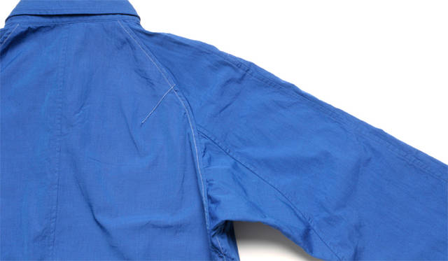 <strong>ESTNATION ｜エストネーション</strong>　正面からはセットイン、背面からはラグランスリーブとピボットスリーブを融合したパターンワーク。脇のパーツをハーフバイアスで裁断することで生まれる伸びにより、可動域が広がる