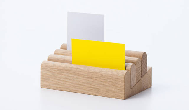 <strong>KARIMOKU NEW STANDARD｜カリモク ニュー スタンダード</strong>　ミラノサローネ2013　<strong>「BERRA」</strong>　スイスを拠点に活動する、ルシアン・ギュミによるデザイン。名刺やポストカードなどを収納しておくための卓上オーガナイザー。重力の法則を活かし、斜めの台の上に乗った木製パーツが、自力でスライドすることによりモノを挟みこむというシステム。BERRAというネーミングは、過去に地滑りを起こしたスイスの山の名前に由来している