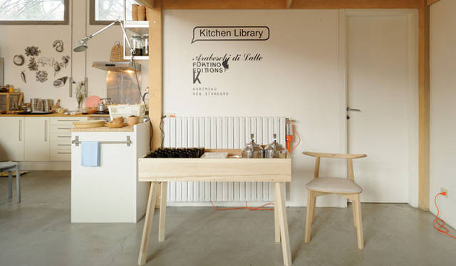 <strong>KARIMOKU NEW STANDARD｜カリモク ニュー スタンダード</strong>　ミラノサローネ2013　アラベスキ・ディ・ラッテのスタジオに、「キッチンライブラリー」と題しラウンジ空間を創出。天井が高く、オープンキッチンを配した心地よい空間に、カリモク ニュー スタンダードの家具をスタイリングしラウンジにしている
