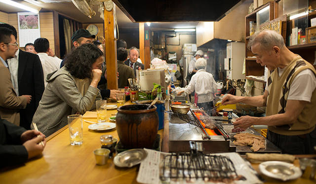 <strong>角田陽太｜東京浪漫酒場</strong>　恵比寿「縄のれん」　お客さんで賑わう店内。カウンターと焼き場の店主