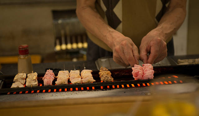 <strong>角田陽太｜東京浪漫酒場</strong>　恵比寿「縄のれん」　電熱線の焼き場に串がならぶ。店主の焼き加減はさすが