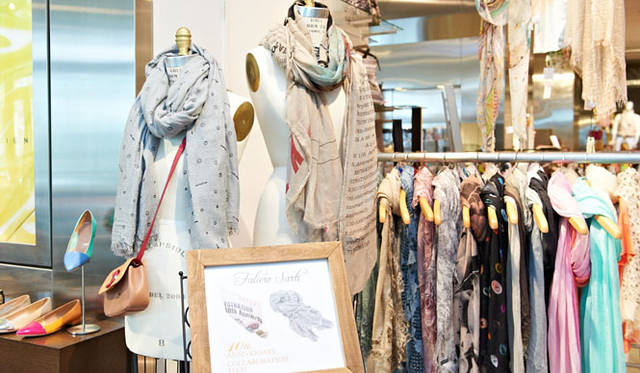 <strong>ESTNATION｜エストネーション</strong>　エストネーション六本木ヒルズ店10周年　10周年を記念して特別にデザインされたストール。ニュースペーパーを模した大胆なプリントとストーンウォッシュによる独特な風合いにも注目。右トルソー／3万7800円。人気のスマイルマークのフロックプリントにエストネーションのロゴを配した限定ストール。左トルソー／3万6750円（ともにファリエロサルティ／エストネーション）