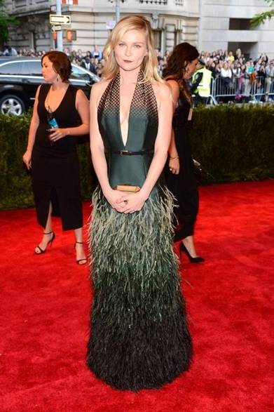 <strong>Kirsten Dunst｜キルスティン・ダンスト</strong><br /><br />ルイ・ヴィドンのドレスで登場した女優のキルスティン・ダンスト。大きく開いたホルターネックの胸元が大胆！　ゴージャスなフェザーづかいが独創的だ。