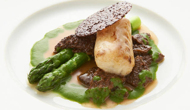 <strong>BEIGE ALAIN DUCASSE TOKYO│ベージュ アラン・デュカス 東京</strong>　パリパリのチョコレートチュイールが白身のスズキに深みをプラス。伊勢原産のアスパラと、ソースのからまったモリーユ茸との食感のコントラストも楽しい「スズキのオーブン焼き、 カカオ豆 グリーンアスパラガスとモリーユ茸のエチュベ」