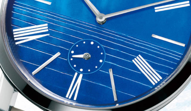 マザー・オブ・パール製の美しい文字盤は、ブルーの濃淡で上半分を空、下半分を海に見立てたデザインがほどこされ、シンプルなローマ数字＆バーインデックスとホワイトストラップが組み合わされる。