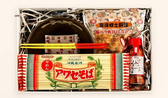 <strong>EAT｜『47 GIFT 2013 -お中元-』をd47ミュージアムで開催</strong><br />沖縄のギフトボックス：軟骨ソーキ煮付け、赤高麗辛子（赤コーレーグース）、やちむん　マカイ６寸、沖縄そばだし、ウメーシ（竹塗箸）、アワセそば　平めん<br />価格｜5100円