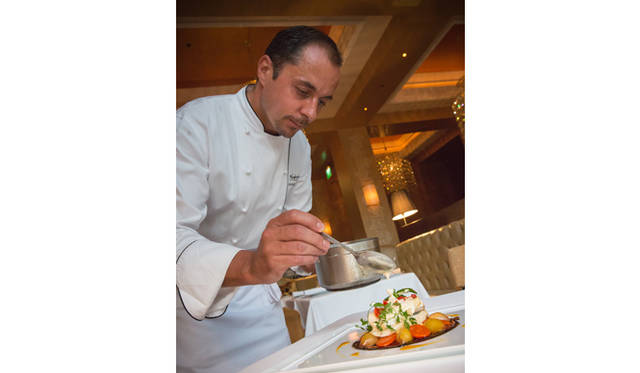 デザートを仕上げるシェフ。写真は「ベリーのシロップ煮を添えたダイオウのパフェ」