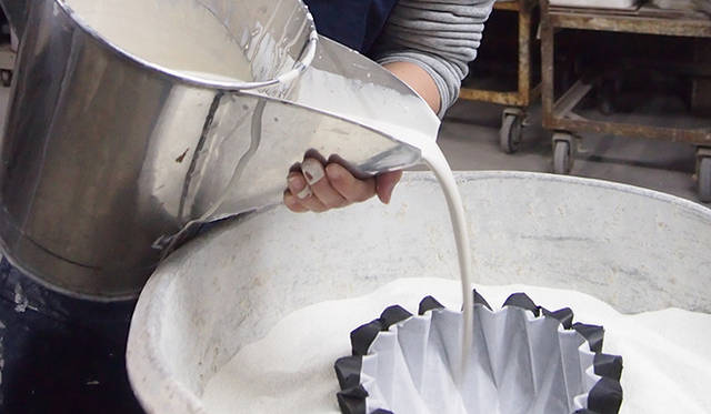 紙を折って作った型に、粘土と水ガラスと水を練って作った泥しょうと呼ばれる原料を流し込み焼成することで、紙のような折りじわが出るという