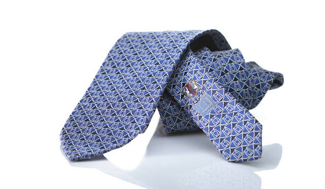 日本代表の試合の舞台となってきた、埼玉スタジアムをモチーフにした幾何学模様をほどこしたウーブンタイ。小剣には日本代表チームエンブレムが織り込まれている。シルク100パーセント。ネクタイ1万6800円（ダンヒル／リシュモン ジャパン）