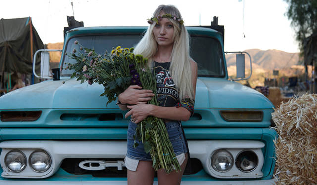 花をかかえた女性。青くペイントされた古いフォードのトラックととてもマッチしています