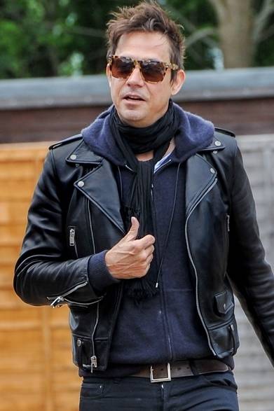 <strong>Jamie Hince｜ ジェイミー・ヒンス</strong><br /><br />ケイト・モスの夫、ジェイミー・ヒンスはネイビーのパーカーに、サンローランのライダースジャケットとブラックデニムとスタイリング。スカーフやサングラスなどの小物づかいで都会的なカジュアルスタイルを完成させた。<br /><br />Courtesy of Saint Laurent