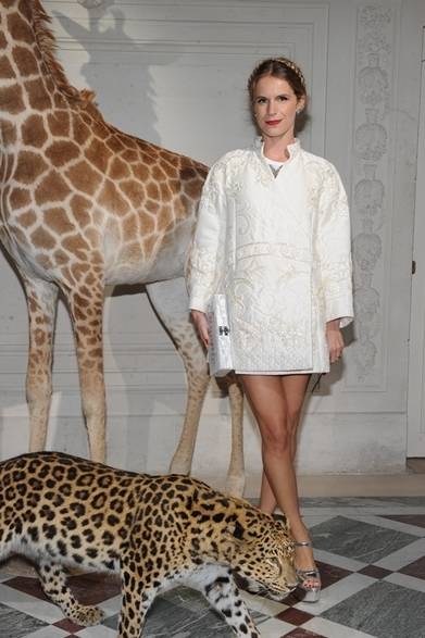 <strong>Eugenie Niarchos｜ユージェニー・二アルコス</strong><br /><br />ソーシャライトのユージェニー・二アルコスはヴァレンティノのコートドレスで登場。花の刺繍を丁寧に飾ったミニ丈のホワイトコートに、シルバーのヒールを合わせ、個性的なドレスアップスタイルに。