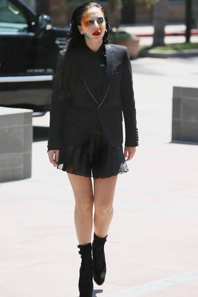 <strong>Lady Gaga｜レディ・ガガ</strong><br /><br />活動を再開したレディ・ガガ。テーラードジャケットにシャツにプリーツミニスカートを合わせたゴシックスタイルは、すべてサンローラン。オールブラックのコーディネイトに、ニュー・シングル『アプローズ（Applause）』のカバーと同じカラフルなフェスペイントで大胆なアクセントをプラスする。<br /><br />Courtesy of SAINT LAURENT