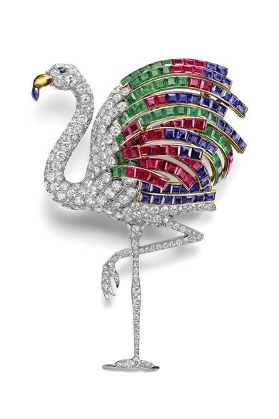 <strong>Cartier｜パリにて『カルティエ、スタイルと歴史』展が開催</strong><br /><br />ウィンザー公爵夫人のフラミンゴ ブローチ（1940）<br /><br /> ウィンザー公爵夫人は大量のジュエリーを所有していたが、そこからある時、一群の貴重な宝石が取り外され、ラ・ペ通り13番地のカルティエ工房のテーブルに置かれたと言われている。そのサファイアやルビーやエメラルドを見たジャンヌ・トゥーサンの脳裏に浮かんだのは、鳥のブローチのアイディアだ。堂々たる大きさと見る者を驚かせる色とりどりの羽根を持つフラミンゴを作ろうと彼女は考えた。ブローチを目にした公爵夫人は、たちどころに心を奪われた。ジャンヌと公爵夫妻のテイストの類似性を物語るエピソードである。その後2010年に、カルティエがこのブローチを入手し、コレクションに加えた。<br /><br />N.Herrmann, Collection Cartier © Cartier