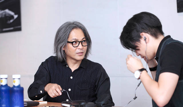 谷川氏所有のヘッドフォンを試す丸若氏。独自のノイズキャンセリング技術をさらに進化させ、圧倒的な消音性能を実現した米ボーズ社の「クワイアットコンフォート」