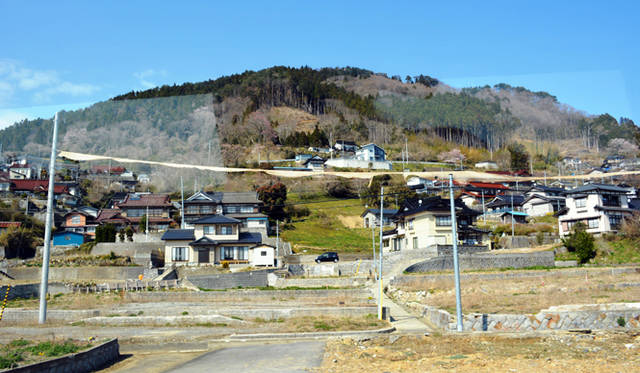 バスの車窓から見えた電柱と電柱を結ぶ黄色いライン。これが防潮堤の高さを示している