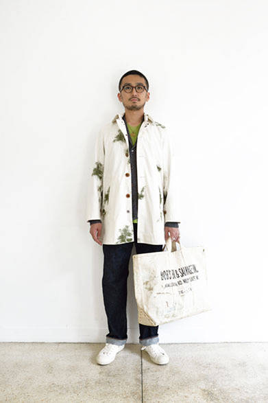 スノーカモステンカラーコート 3万6000円、ショールカラーカーディガン 2万5000円、クルーネックTシャツ 4500円、5Pデニムパンツ 1万6000円、メガネ 2万5000円、ネックレス 9800円、スニーカー 1万3000円、トートバッグ 1万8000円