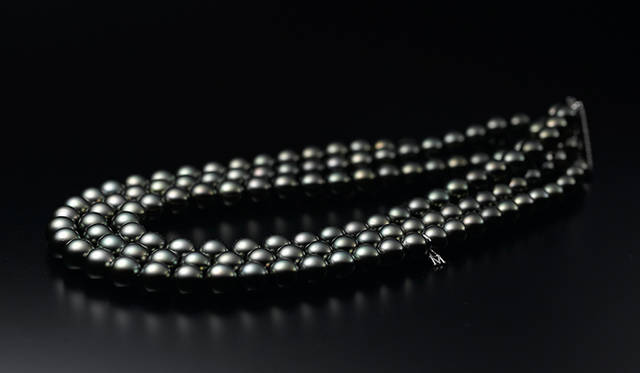 タヒチ近海で採れた黒蝶真珠を3連に束ねたボリュームのあるネックレス。入念なマッチング作業により、サイズも輝きも、肉眼ではまったく見分けがつかないほど完璧に揃い、首周りに圧倒的な存在感を与える。450万円［税別］（ミキモト／ミキモト カスタマーズ・サービスセンター）