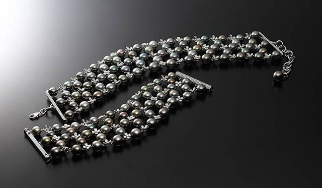 異なる色味を持った黒蝶真珠を、ランダムに配置してトータルバランスを演出する。真珠と真珠の間の小花はダイヤモンド製。ネックレス（合計7.61ctのダイヤモンド）1100万円［税別］、ブレスレット（合計7.89ctのダイヤモンド）850万円［税別］（ともにミキモト／ミキモト カスタマーズ・サービスセンター）　※この商品は女性モデルが使用