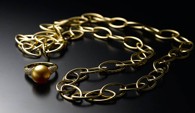 金色に輝く通称“ゴールデンパール”は、白蝶真珠の一種。この稀少性の高い真珠に合計0.49ctのダイヤモンドをセッティングしたリングは、イエローゴールドK18製のチェーンタイプネックレスと合わせたい。リング77万円［税別］、ネックレス57万円［税別］（ともにミキモト／ミキモト カスタマーズ・サービスセンター）