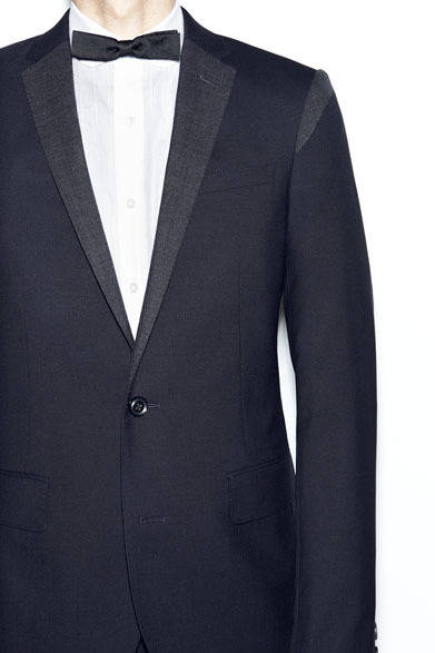 ラペルとショルダーにおなじ生地で色ちがいを合わせたバイカラーのジャケット7万1000円、繊細なコットンのシャンブレーで、ショートスリーブ仕立て。ブザムにピンタックがほどこされ、ジャケットのVゾーンを華やかに演出するシャツ3万3000円、アジャスター付きのコットングログランのタイ8000円　※すべて税抜価格