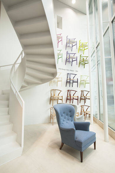 壁面のYチェアは、Yチェア誕生60年を記念して製作された限定品。手前は、フリッツ・へニングセンがデザインした名作の復刻版「ヘリテージチェア」