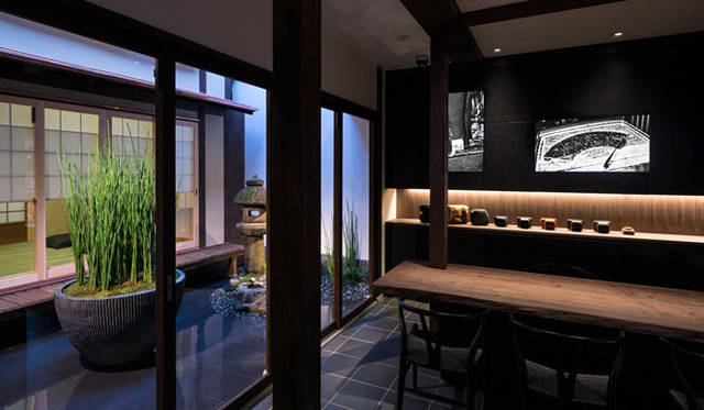 右がカウンターで、左が改装前の町家からそのまま引き継いでいる坪庭の石灯籠　© Stirling Elmendorf