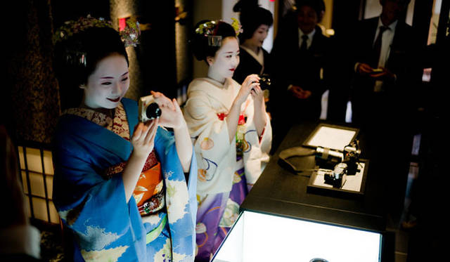 店内でライカを手に取る舞妓さん、芸子さん