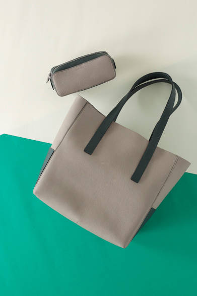 メゾンタクヤで人気の高いドイツ製の極上のシュリンクカーフを使ったトートバッグの新シリーズが登場。革素材以外一切使用せず、カラーブロックのアクセントがデザインポイントの新作で、ポケットも内外に計4カ所配置。今回の“ドレッシンググリーン”のテーマに沿って、阪急メンズのみのプラチナベージュ×ダークの限定色を展開。トラベルポーチも同様の限定色で、バッグインバッグとしても重宝するサイズとなっている<br />バイカラートート（縦32×横33.5×マチ16.5cm）17万8200円、（縦20.5×横8.5×マチ7cm）ポーチ4万1040円［ともに阪急メンズ限定］（メゾンタクヤ／阪急メンズ東京1階）