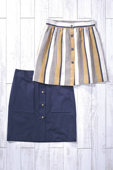 WOMENS｜ノスタルジックな雰囲気を感じさせるストライプ柄とフロントボタンのデザインが上品。ひざ上丈なので、さらっと涼しげなスタイリングに合わせたい。上からリネンストライプスカート 2万7000円、フロントボタンスカート3万3000円（Les Prairies De Paris）<br />※税抜き価格