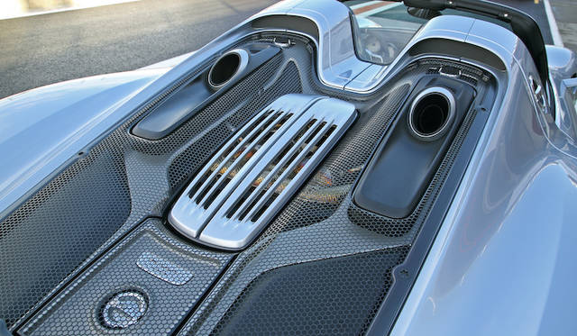 porsche_918_spyder_043 排気が上方に向かって放たれるのは、たんにデザイン的な要素に留まらず「エンジンルーム内の冷却性に優れ、背圧低減にも寄与するとともに、リアタイヤの温度上昇を抑制することでサーキット連続走行時のラップタイム低下を緩和する」などと、数かずの実利的メリットが謳われてもいる