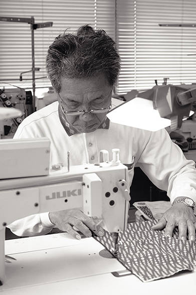 「NALUTO TRUNKS（ナルト トランクス）」は、徳島県鳴門市の水着メーカー「山口縫製」の2代目、山口輝陽志氏が立ち上げたサーフトランクスブランド。写真は先代の山口道雄氏