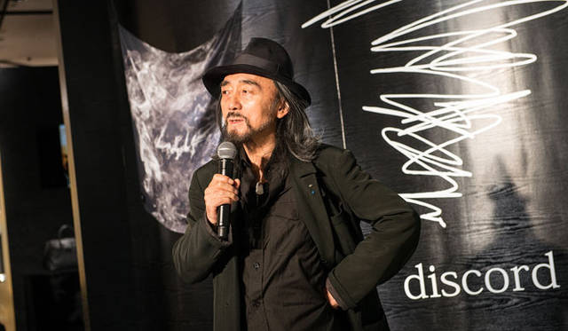 discordのイメージを山本耀司氏自らが表現したブランドロゴの前で