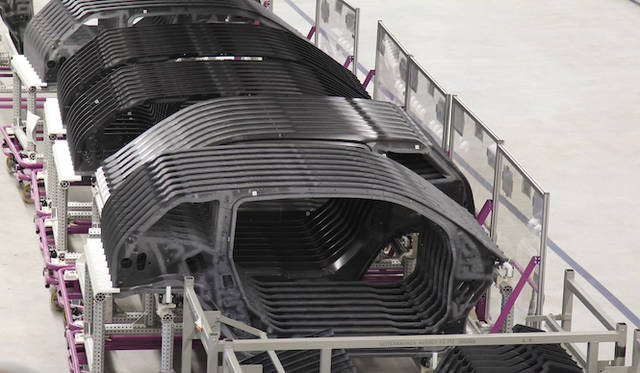 予備形成された炭素繊維のスタックは、RTM（レジン トランスファー モールディング）法によって繊維と樹脂が結合。世界ではじめて、自動化による大型CFRP製複合コンポーネントの量産に成功した