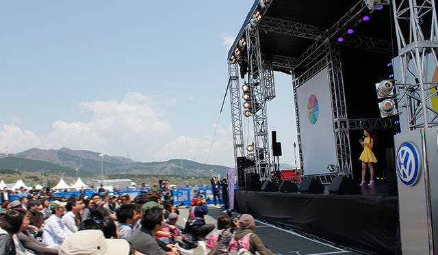 メインステージでは、クルマを愛するDJとして有名なピストン西沢氏がトークショーと会場内専用のラジオ放送を担当。その内容は、館内放送で流されたほか、来場者にプレゼントされた携帯ラジオでも楽しめ、サーキットに誕生した一日限りのスペシャルFM局として、軽快なトークと音楽でイベントを終日盛り上げた