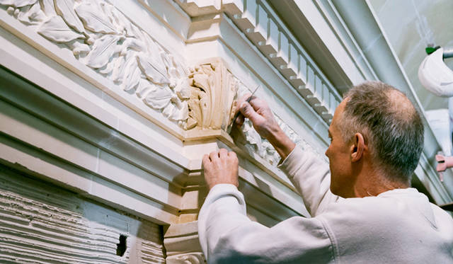 歴史的建造物の修復を専門とするドゥガンヌ社の化粧しっくい職人がル・ロビーの隅石を修繕