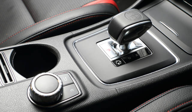 AMGロゴ入りのセレクトレバーはAMGアドバンストパッケージにふくまれるオプション。パーキングブレーキはボタン式。その横は「コンフォート」「スポーツ」「マニュアル」の3つのモードを切り替えるトグル式のスイッチ。<br />