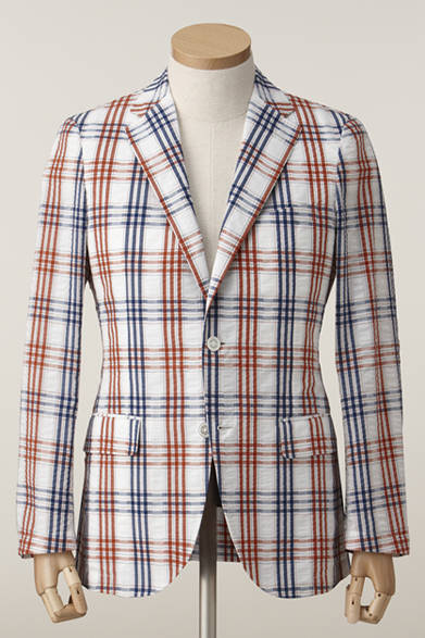 英国人が植民地で発展させたコロニアルスタイル、サファリスタイルをイメージしたシアサッカー地のジャケット｡軽快な背抜き仕立てで、リゾート感溢れる大柄のチェック地を用いて仕立てた｡同素材でバミューダパンツを展開し､セットアップでも楽しめる。ジャケット3万7800円