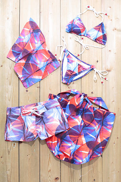 WOMENS｜よりリゾート感のあるグラフィックは、南国の植物がモチーフとなっている。おなじスウィムウェアのシリーズで、スカーフもラインナップする。左上から時計まわりに、スカーフ8000円、ビキニ1万7000円、バッグ1万6000円、ショーツ1万6000円（すべてスワミーズ）<br />※すべて税抜き価格