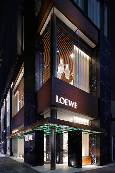 あたらしいブランドロゴには、「アラバスターストーン」という半透明の石が用いられ、穏やかな光とともに夜の表参道にあらわれる。エメラルドグリーンのめのう石を敷いたキャノピー、地上2階から1階までつながるストラクチャードカーテンなど、外観においても独特の存在感をアピールする