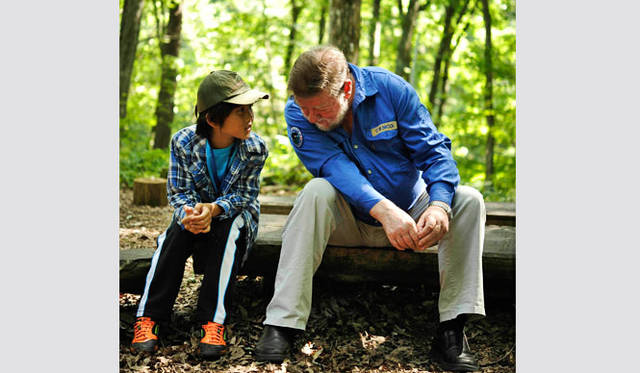 <strong>森の学校｜C.W.ニコル</strong>　アファンの森を訪れた東松島市の子どもの話を聴くニコル氏（写真：一般財団法人C.W.ニコル・アファンの森財団）