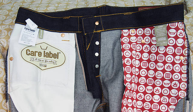 ポケットのスレキにもデザインがほどこされている。製品の取扱い絵表示を総柄でほどこす、ユニークなアプローチ