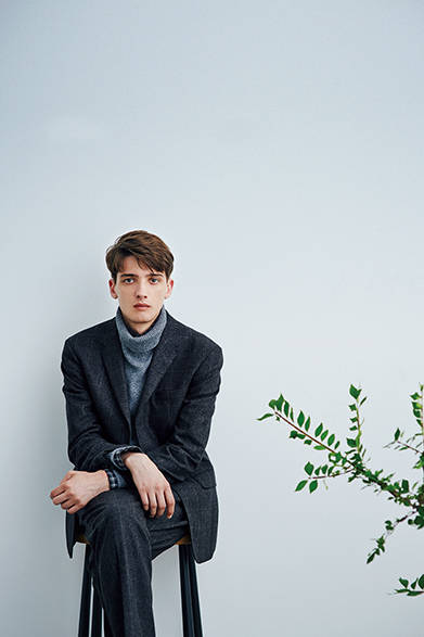 クラシックな印象のある生地「P.O.W（プリンス・オブ・ウェールズ）」にカラー変化をつけて仕上げているセットアップとざっくりしたタートルでリラックスしたコーディネイト。袖口と襟もとからのぞかせているチェックのシャツが絶妙におしゃれ。ジャケット9万7200円、ニット3万5640円、シャツ3万240円、トラウザーズ4万8600円（すべてマーガレット・ハウエル）