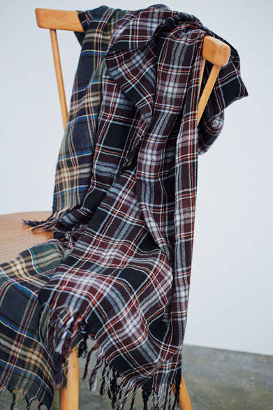 マーガレット・ハウエルオリジナルのタータンチェック柄は、グレーベースとボルドーベースの2色展開。たとえば黒のトーンオントーンでまとめた着こなしに加えると効果的なポイントカラーに。英国メイドの素材感も抜群だ。スカーフ各3万3480円（マーガレット・ハウエル）