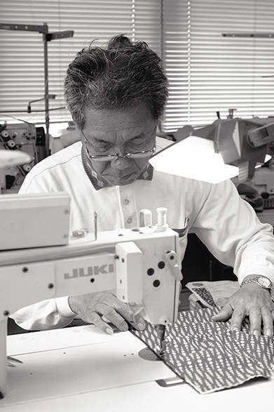 「NALUTO TRUNKS（ナルト トランクス）」は、徳島県鳴門市の水着メーカー「山口縫製」の2代目、山口輝陽志氏が立ち上げたサーフトランクスブランド。写真は先代の山口道雄氏