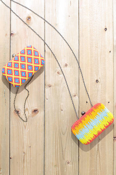 WOMENS｜インドの職人によってハンドメイドで作られるビーズのバッグは、ビーチやリゾートで目を引く華やかなカラーが特徴。チェーンが付属しているのでクラッチバッグ、ショルダーバッグと2WAYで使用できる。左から、ビーズクラッチ各2万8000円（ともにサンティ）<br />※ともに税抜き価格