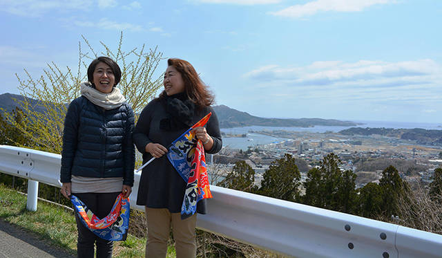 私たちを出迎えるためのミニ大漁旗を手にする斉藤和枝さんと小野寺紀子さん
