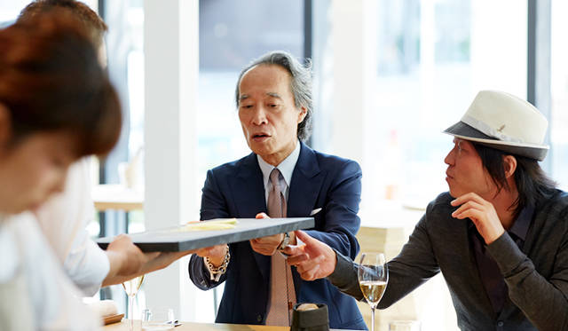 一品目を終わると、目の前の“黒い”まな板に興味を示した川上氏と大住。「フランスでは、使う材料によってまな板の色を変えるのが一般的なんですよ」と小林シェフ。客席とキッチンの距離が近いため、こうしたさりげない会話が自然とはじまる