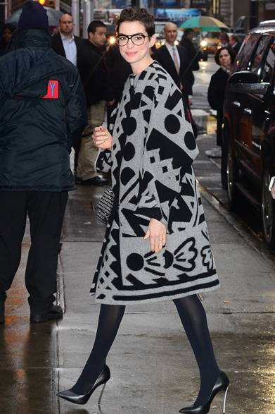 <strong>Anne Hathaway｜アン・ハサウェイ</strong><br /><br />ロンドンの街でアン・ハサウェイをキャッチ。バーバリーのブランケットコートを主役に、個性的な黒縁メガネやフェミニンなピンヒールを合わせ、プレイフルなシックスタイルを仕上げた。