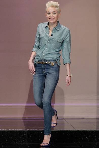 <strong>Miley Cyrus｜マイリー・サイラス</strong><br /><br />アメリカのテレビ番組『THE TONIGHT SHOW WITH JAY LENO』に登場したマイリー・サイラス。サンローランのシャツとスキニーを合わせた“デニム・オン・デニム”スタイルが個性的。チェーンベルト、ネックレスなどゴールドの小物使いでグラマラスなスタイリングに。<br /><br />COURTESY OF SAINT LAURENT